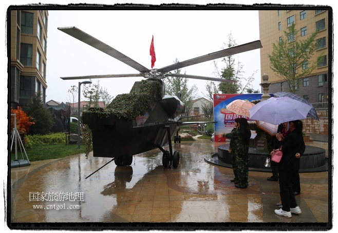 小區(qū)突然出現(xiàn)“飛機坦克”，其中殲15艦載戰(zhàn)斗機一架、99式主戰(zhàn)坦克一輛、武直-10武裝直升機一架，吸引了眾多市民雨中圍觀、合影。